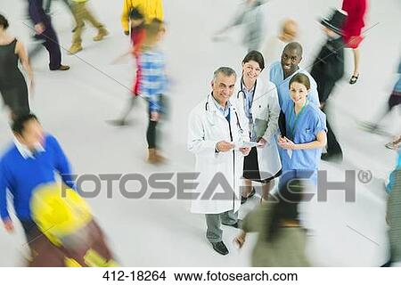 Portrait of confident doctors and nurses among crowd View Large Photo Image Picture - Portrait of confident doctors and nurses among crowd. Fotosearch