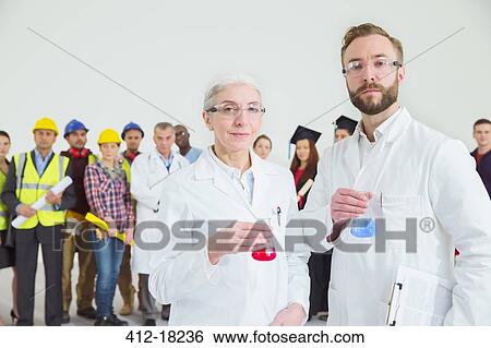 Stock Photograph - Portrait of scientists with workforce in background. Fotosearch