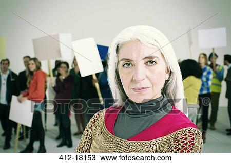 Portrait of serious woman with protesters in background View Large Photo Image Stock Image - Portrait of serious woman with protesters in background. Fotosearch