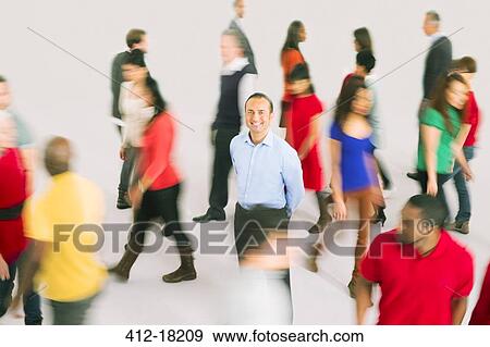 Portrait of smiling businessman standing out from the crowd View Large Photo Image Stock Photo - Portrait of smiling businessman standing out from the crowd. Fotosearch
