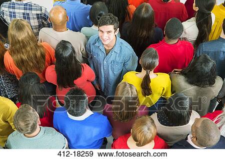 Portrait of smiling man standing out from the crowd View Large Photo Image Stock Photo - Portrait of smiling man standing out from the crowd. Fotosearch