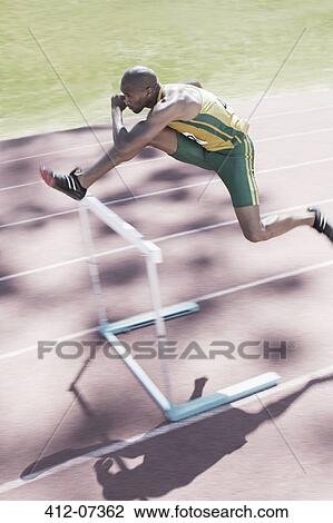 Runner clearing hurdle on track View Large Photo Image Stock Image - Runner clearing hurdle on track. Fotosearch