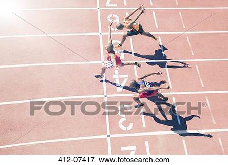 Runners crossing finish line on track View Large Photo Image Stock Photo - Runners crossing finish line on track. Fotosearch