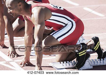 Runners poised at starting blocks on track View Large Photo Image Stock Image - Runners poised at starting blocks on track. Fotosearch
