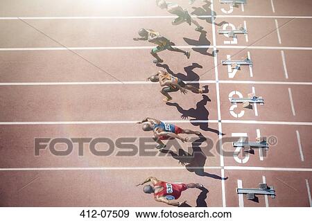 Runners taking off from starting blocks on track View Large Photo Image Stock Photo - Runners taking off from starting blocks on track. Fotosearch