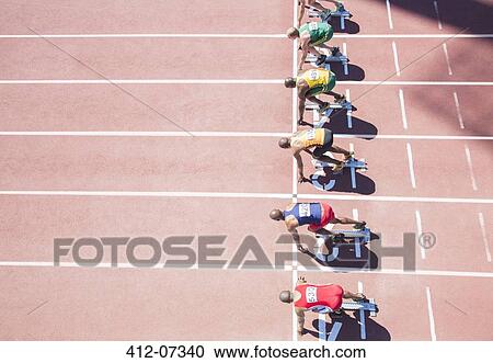Runners waiting at starting block on track View Large Photo Image Stock Image - Runners waiting at starting block on track. Fotosearch