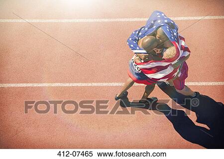 Runners wrapped in American flag hugging on track View Large Photo Image Stock Photography - Runners wrapped in American flag hugging on track. Fotosearch