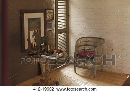 Stock Image - Side table and decorations in rustic bedroom. Fotosearch