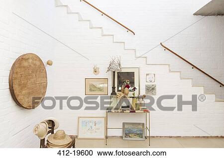 Side table and wall hangings by staircase View Large Photo Image Stock Image - Side table and wall hangings by staircase. Fotosearch