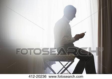 Silhouette of man using cell phone View Large Photo Image Stock Photograph - Silhouette of man using cell phone. Fotosearch