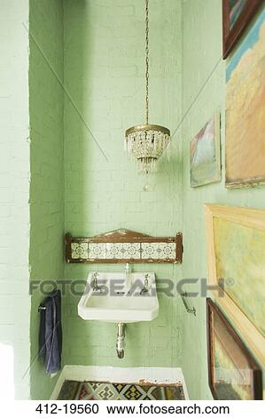 Stock Image - Sink and chandelier in rustic bathroom. Fotosearch