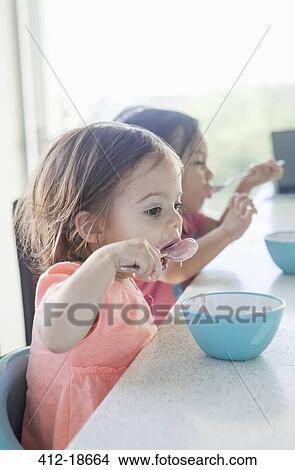 Sisters eating breakfast together View Large Photo Image Picture - Sisters eating breakfast together. Fotosearch