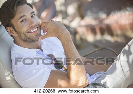 Stock Photo - Smiling man relaxing outdoors. Fotosearch
