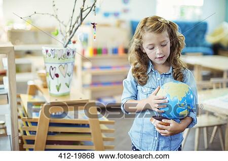 Student examining globe in classroom View Large Photo Image Stock Photo - Student examining globe in classroom. Fotosearch