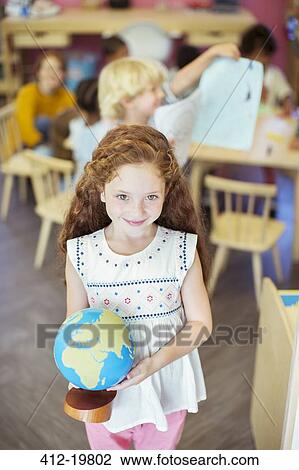 Student holding globe in classroom View Large Photo Image Stock Image - Student holding globe in classroom. Fotosearch