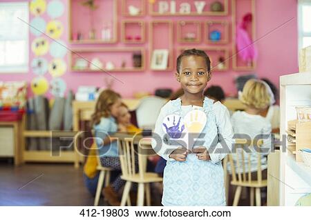 Student holding painting in classroom View Large Photo Image Stock Image - Student holding painting in classroom. Fotosearch