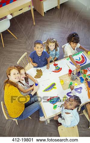 Students and teacher painting in classroom View Large Photo Image Stock Image - Students and teacher painting in classroom. Fotosearch