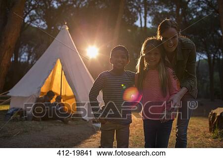 Stock Image - Students and teacher smiling at campsite. Fotosearch