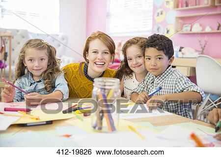 Stock Photograph - Students and teacher smiling in classroom. Fotosearch