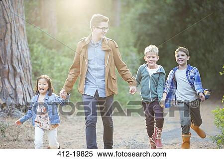 Stock Photography - Students and teacher walking in forest. Fotosearch