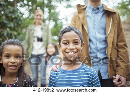 Stock Image - Students and teachers smiling in forest. Fotosearch