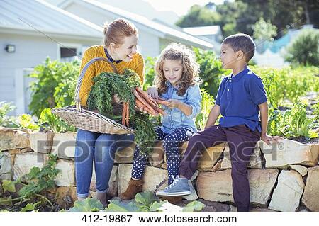 Stock Photo - Teacher and students in vegetable garden. Fotosearch