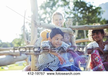 Stock Photo - Teacher and students playing on play structure. Fotosearch