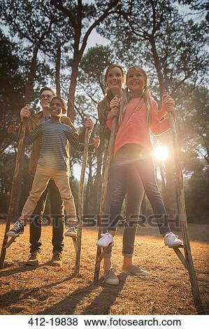 Teachers helping students walk on stilts outdoors View Large Photo Image Stock Photo - Teachers helping students walk on stilts outdoors. Fotosearch