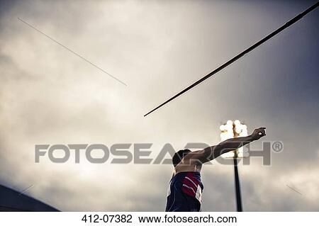 Stock Image - Track and field athlete throwing javelin. Fotosearch