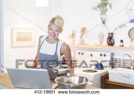 Woman at laptop cooking in kitchen View Large Photo Image Stock Image - Woman at laptop cooking in kitchen. Fotosearch