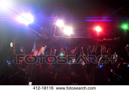 Woman crowd surfing at concert View Large Photo Image Stock Photograph - Woman crowd surfing at concert. Fotosearch