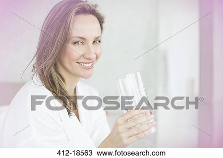 Woman having glass of water in bedroom View Large Photo Image Stock Image - Woman having glass of water in bedroom. Fotosearch