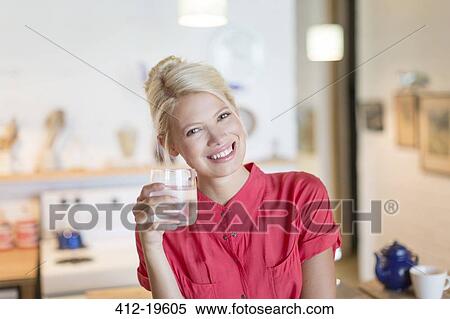 Woman having glass of water in kitchen View Large Photo Image Stock Photography - Woman having glass of water in kitchen. Fotosearch