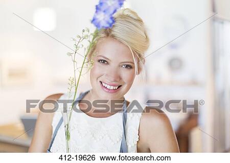 Woman holding flower in rustic kitchen View Large Photo Image Stock Photograph - Woman holding flower in rustic kitchen. Fotosearch