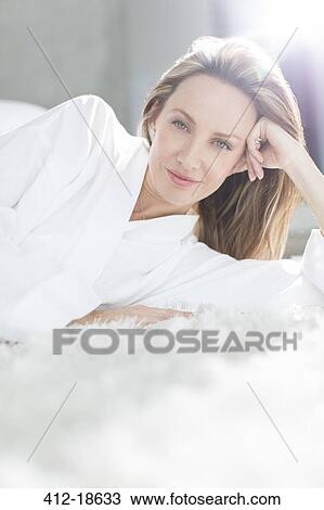 Woman in bathrobe laying on bed View Large Photo Image Stock Image - Woman in bathrobe laying on bed. Fotosearch