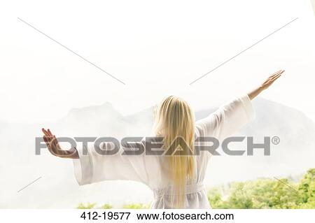 Stock Photo - Woman in bathrobe overlooking landscape. Fotosearch