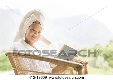 Stock Photo - Woman in bathrobe reading outdoors. Fotosearch