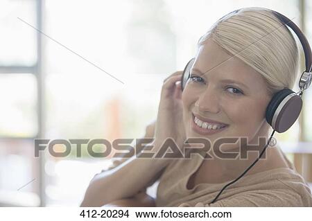 Picture - Woman listening to headphones. Fotosearch