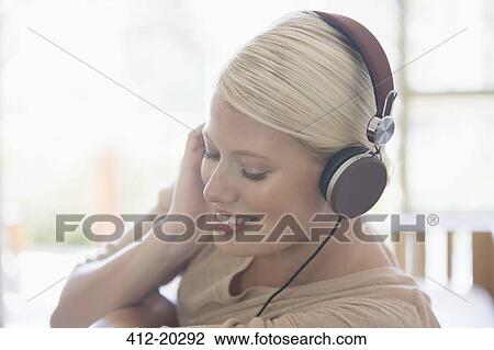 Woman listening to headphones View Large Photo Image Stock Image - Woman listening to headphones. Fotosearch