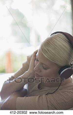 Woman listening to headphones View Large Photo Image Stock Image - Woman listening to headphones. Fotosearch