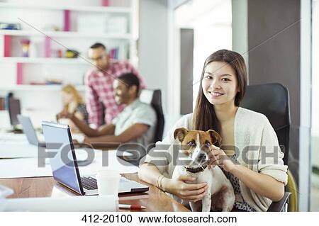 Woman petting dog in office View Large Photo Image Stock Image - Woman petting dog in office. Fotosearch