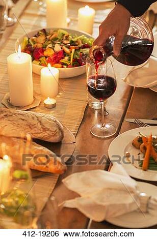 Woman pouring wine at dinner party View Large Photo Image Stock Photograph - Woman pouring wine at dinner party. Fotosearch