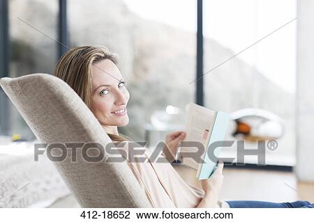 Woman reading in armchair View Large Photo Image Stock Image - Woman reading in armchair. Fotosearch