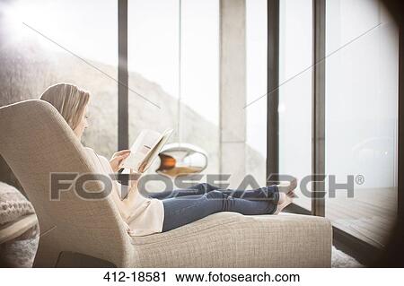 Woman reading on sofa in modern living room View Large Photo Image Stock Image - Woman reading on sofa in modern living room. Fotosearch
