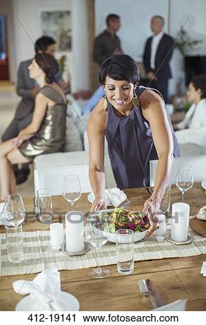 Woman serving food at dinner party View Large Photo Image Stock Image - Woman serving food at dinner party. Fotosearch