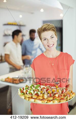 Woman serving food at party View Large Photo Image Stock Photo - Woman serving food at party. Fotosearch