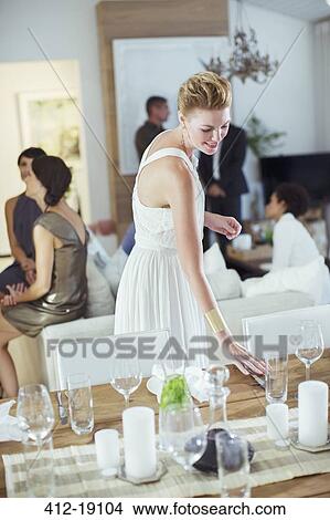 Woman setting table at dinner party View Large Photo Image Picture - Woman setting table at dinner party. Fotosearch