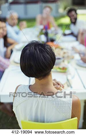 Woman sitting at table outdoors View Large Photo Image Picture - Woman sitting at table outdoors. Fotosearch