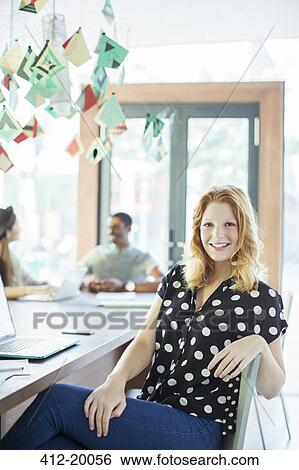 Woman smiling at conference table in office View Large Photo Image Stock Photograph - Woman smiling at conference table in office. Fotosearch