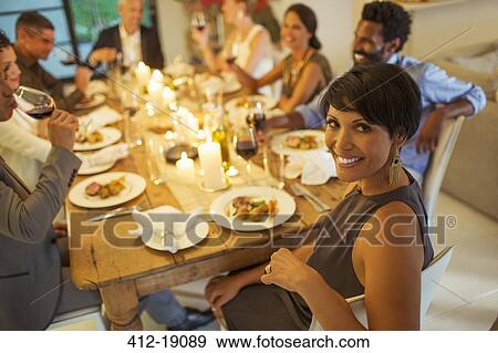 Stock Photo - Woman smiling at dinner party. Fotosearch